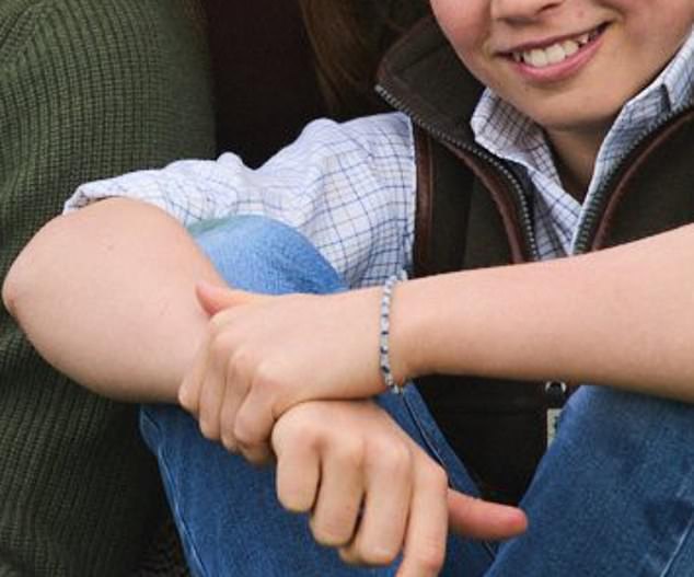 Prince George, who wore denim jeans, a checked shirt and a brown gilet, was also seen wearing a fabric friendship bracelet