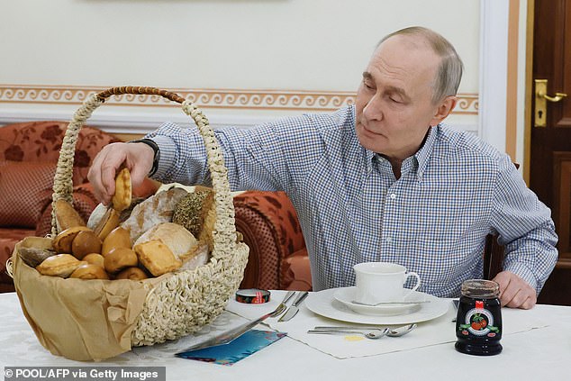 The latest attack from Vladimir Putin's armed forces comes after he wrapped up his end of year press conference in Moscow, in which he declared he was 'ready and willing' for Ukraine peace talks. Pictured: Putin tastes pastries from a bakery sent by its owner following his annual end-of-year press conference on December 20