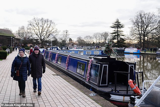 People walk by canal boats in Stratford-upon-Avon in Warwickshire amid cold temperatures