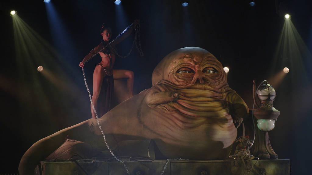 a performer dressed as Leia dances with a chain atop a giant Jabba The Hutt puppet/prop at The Empire Strips Back