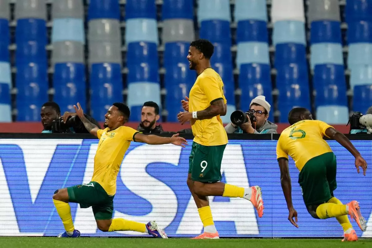 South Africa's Oswin Appollis, left, celebrates after scoring a goal during the Africa Cup of Nations group B soccer match between Angola and South Africa in Marrakech, Morocco, Monday, Dec. 22, 2025. (AP Photo/Themba Hadebe)