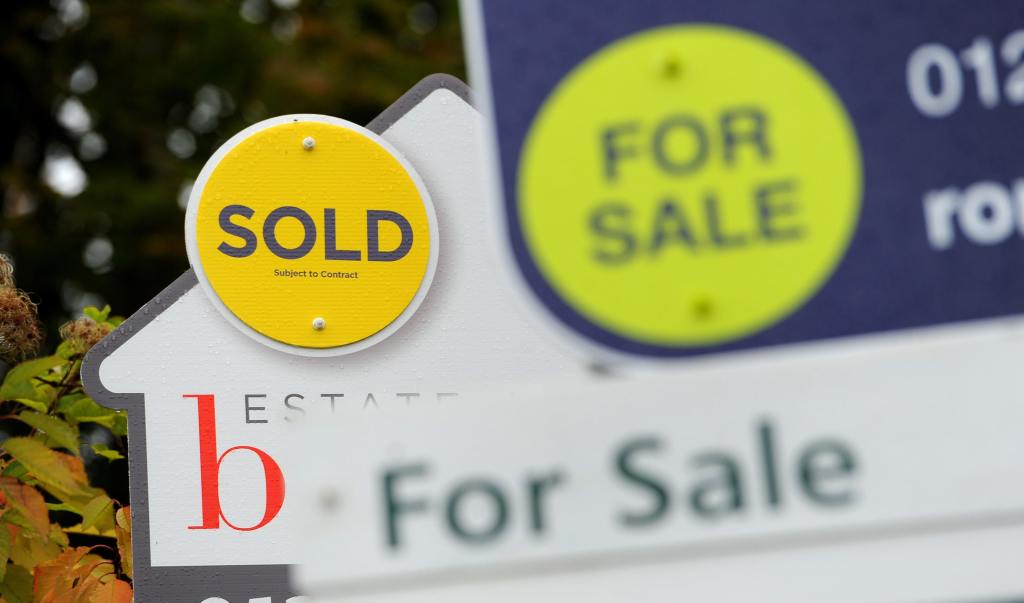 Estate agent signs with the word 'Sold' most prominent