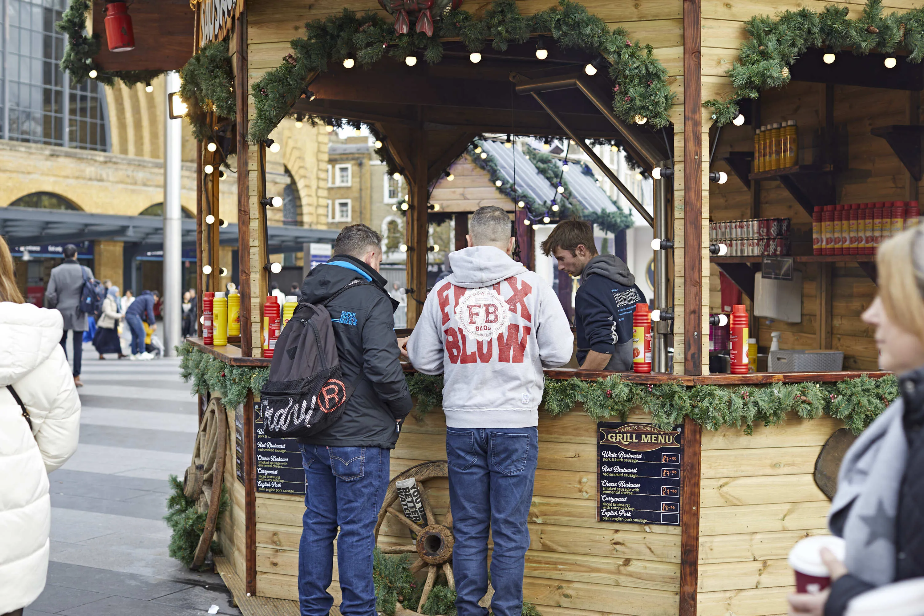 Photo of people at a hot dog stand in a christmas market outside King's Cross station