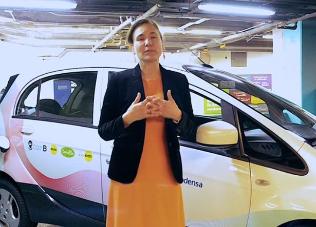 Guzman speaking in front of a car