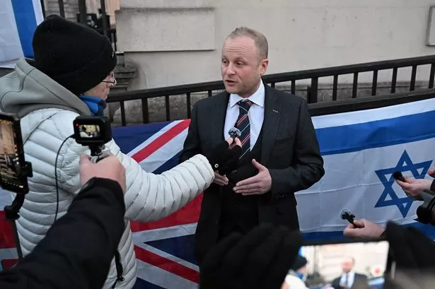 Jamie Bryson pictured at the High Court in Belfast after a judge rejected a legal bid to remove a Palestinian flag that has been erected on Belfast City Hall