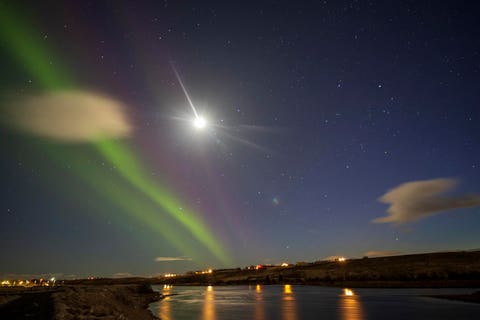 Hella Iceland on April 16, 2024. Aurora borealis northern lighs over the city by the river.