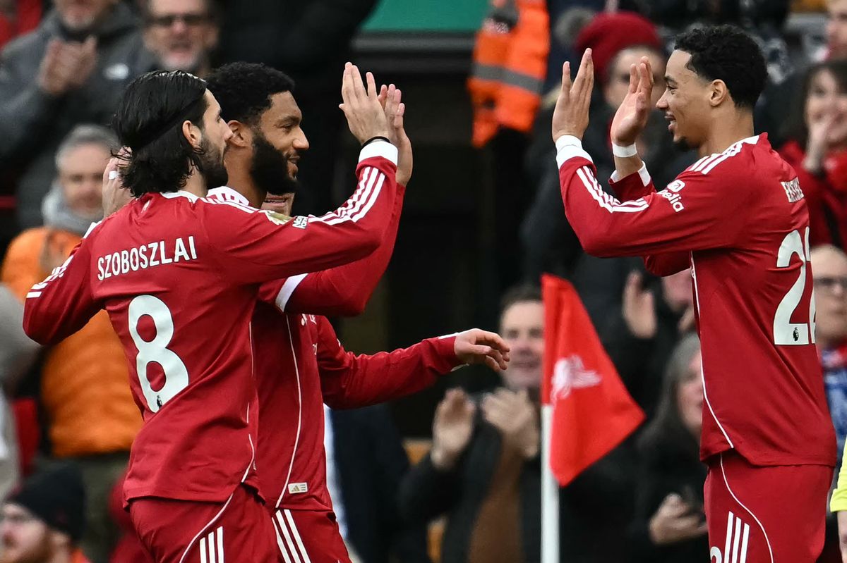 Liverpool's French striker #22 Hugo Ekitike (R) celebrates scoring the opening goal during the English Premier League football match between Liverpool and Brighton and Hove Albion at Anfield in Liverpool, north west England on December 13, 2025. (Photo by Paul ELLIS / AFP via Getty Images) / RESTRICTED TO EDITORIAL USE. No use with unauthorized audio, video, data, fixture lists, club/league logos or 'live' services. Online in-match use limited to 120 images. An additional 40 images may be used in extra time. No video emulation. Social media in-match use limited to 120 images. An additional 40 images may be used in extra time. No use in betting publications, games or single club/league/player publications. / 
