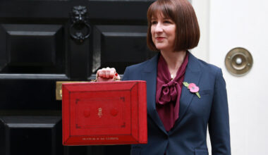 Rachel Reeves speaking at a podium during a business conference, wearing a professional suit, engaging with the audience.