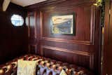 Dark wood-paneled walls, leather Chesterfield sofas, and portholes feel right at home in the converted boat hotel.