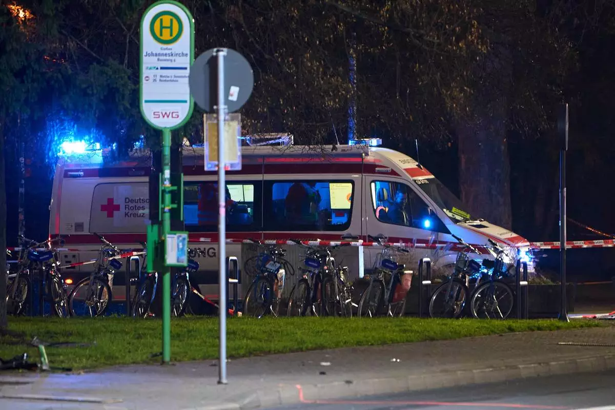 A German Red Cross (DRK) emergency vehicle stands behind a barrier tape, at the site where a car is said to have driven into a bus stop and several people were injured, according to the police, in Giessen, Germany, Monday Dec. 22, 2025. (Sascha Ditscher/dpa via AP)