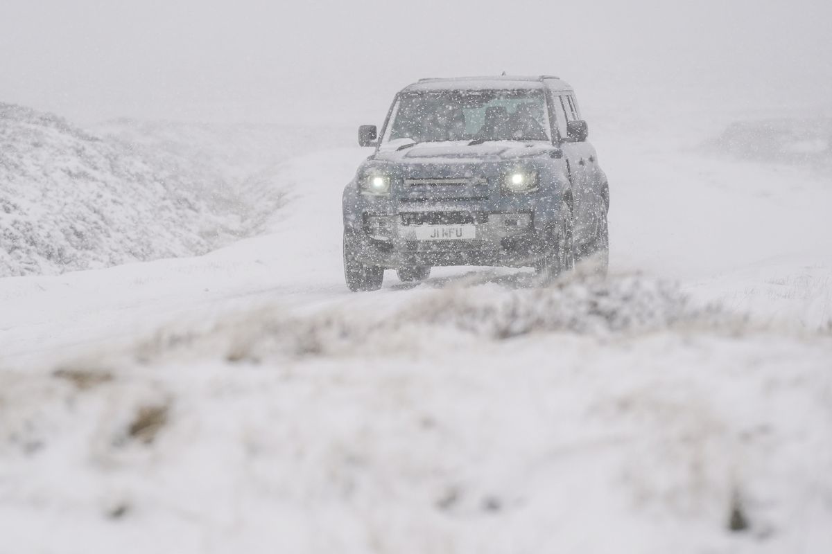 Stock image of a car driving through snow