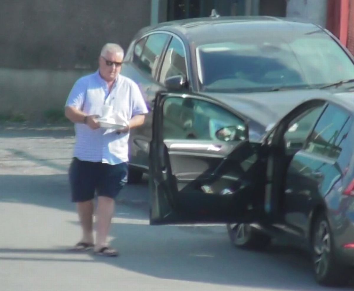 Covert footage showing a man carrying items near a car