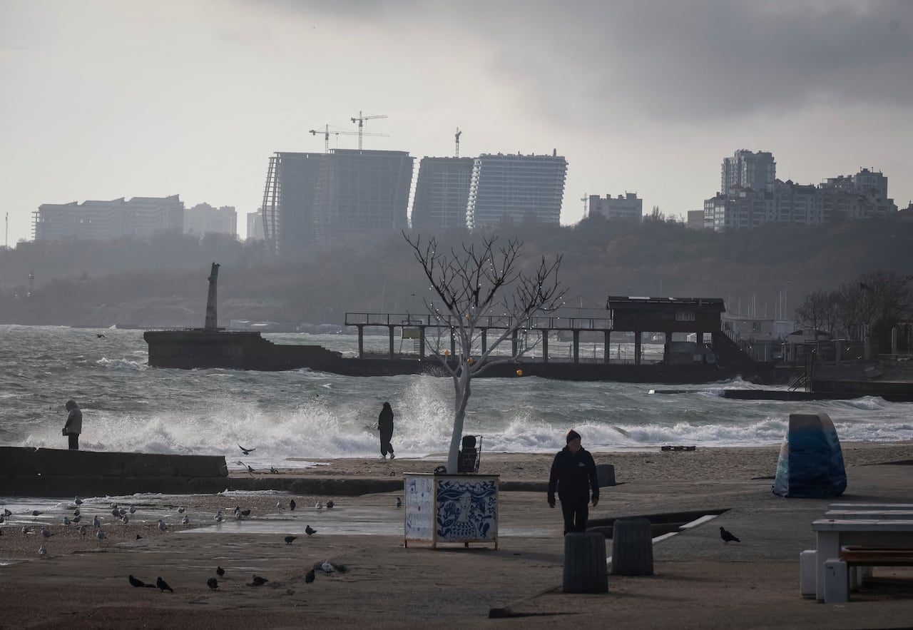 People walk along a shoreline.