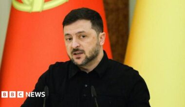 Ukrainian President Volodymyr Zelensky speaks during a joint press conference with Portuguese Prime Minister Montenegro following their meeting in Kyiv, Ukraine, 20 December 2025. he is dressed in a black shirt and in the background the Portuguese and the Ukrainian flags can be seen