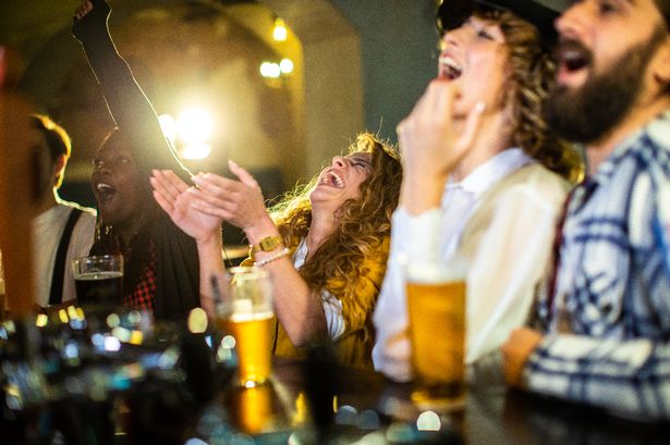 Stock image of people at a bar drinking and celebrating
