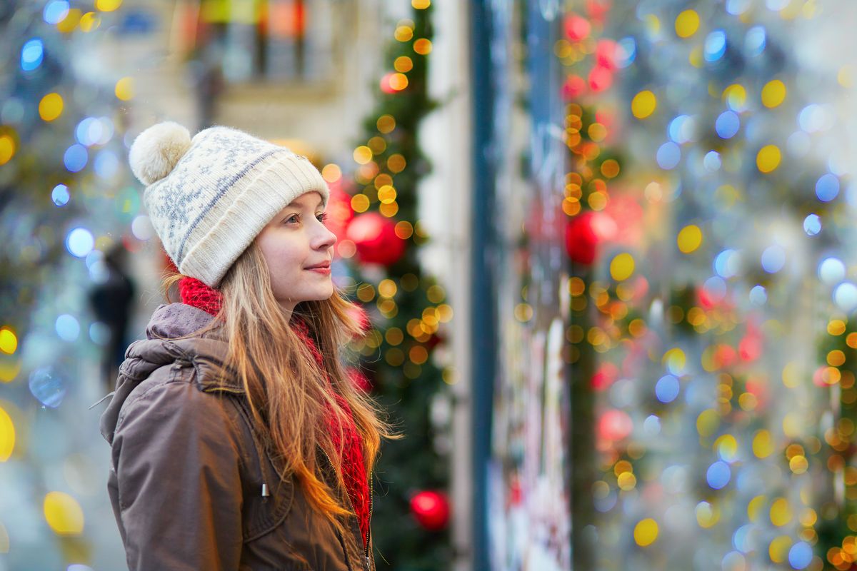Girl on a street looking through window 