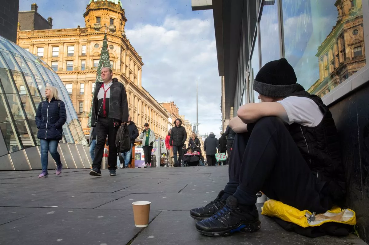 A homeless man sits in St Enoch Square in Glasgow in November 2024