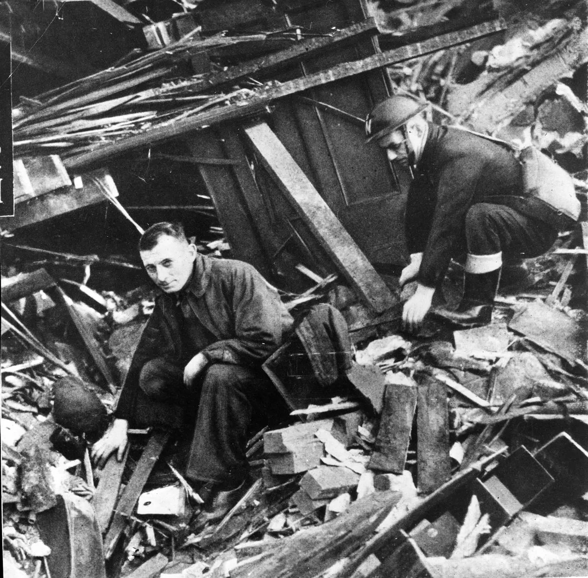 Two members of the emergency services sift through the rubble following the Christmas Blitz 