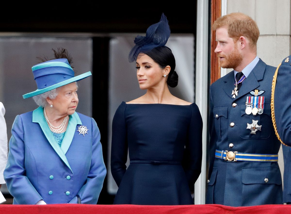  Queen Elizabeth II, Meghan, Duchess of Sussex and Prince Harry, Duke of Sussex watch a flypast to mark the centenary of the Royal Air Force from the balcony of Buckingham Palace on July 10, 2018 in London, England. 