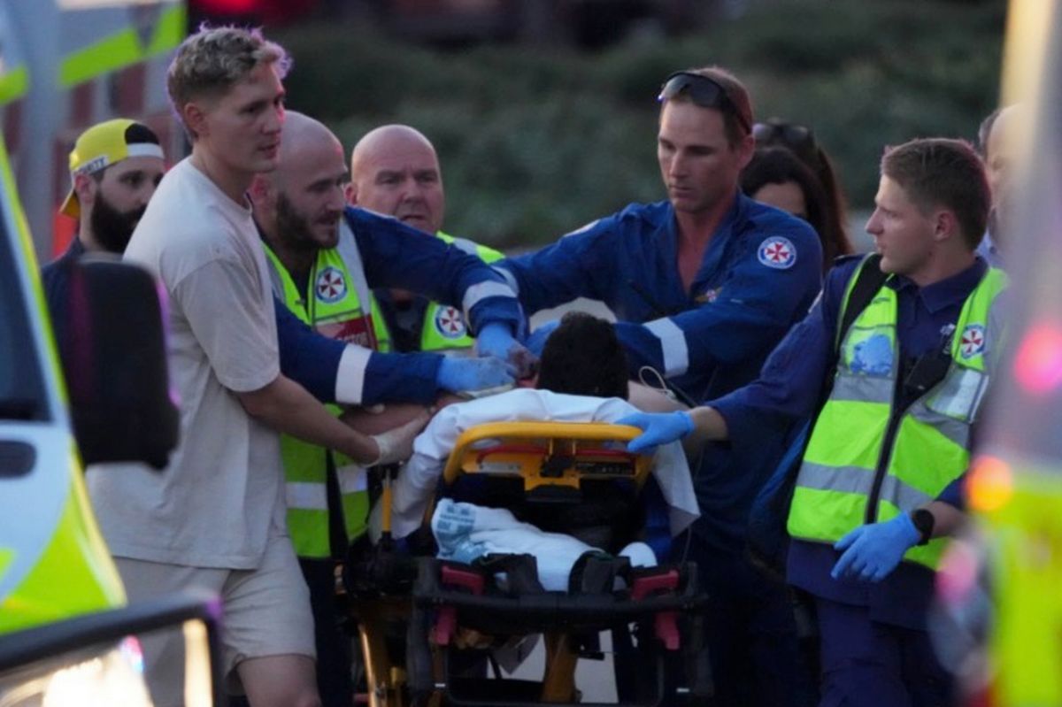Emergency workers transport a person on a stretcher after a reported shooting at Bondi Beach 