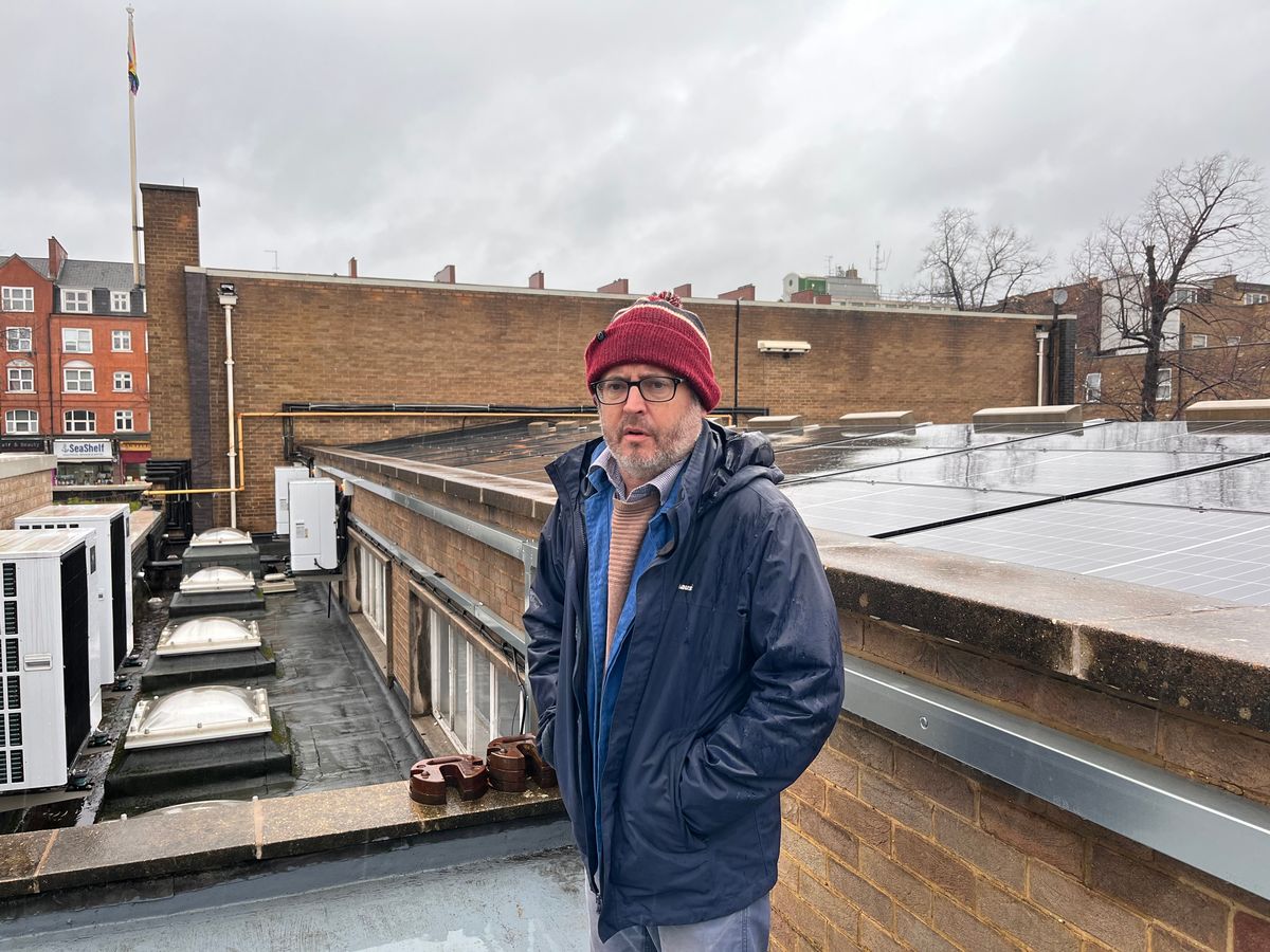 Tom Campbell pictured on roof in hat and raincoat