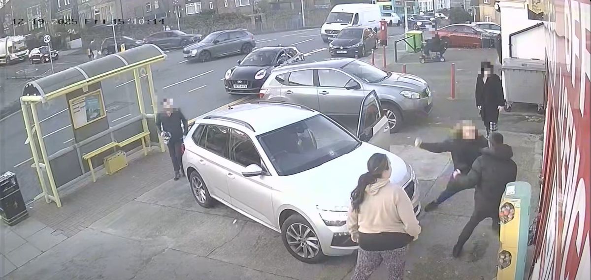 A car is driven up onto the pavement in front of the New Brighton shop as the brawl continues