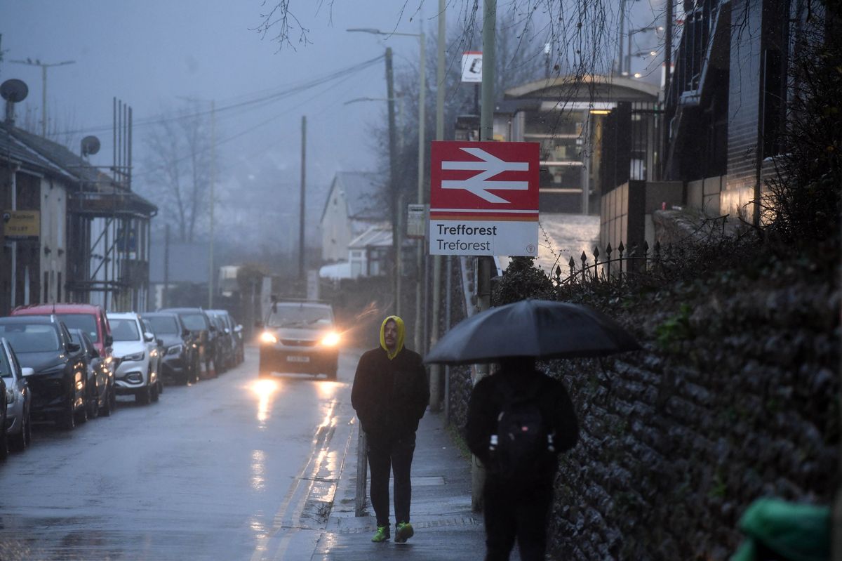 People walking in a residential street on a wet and grey day