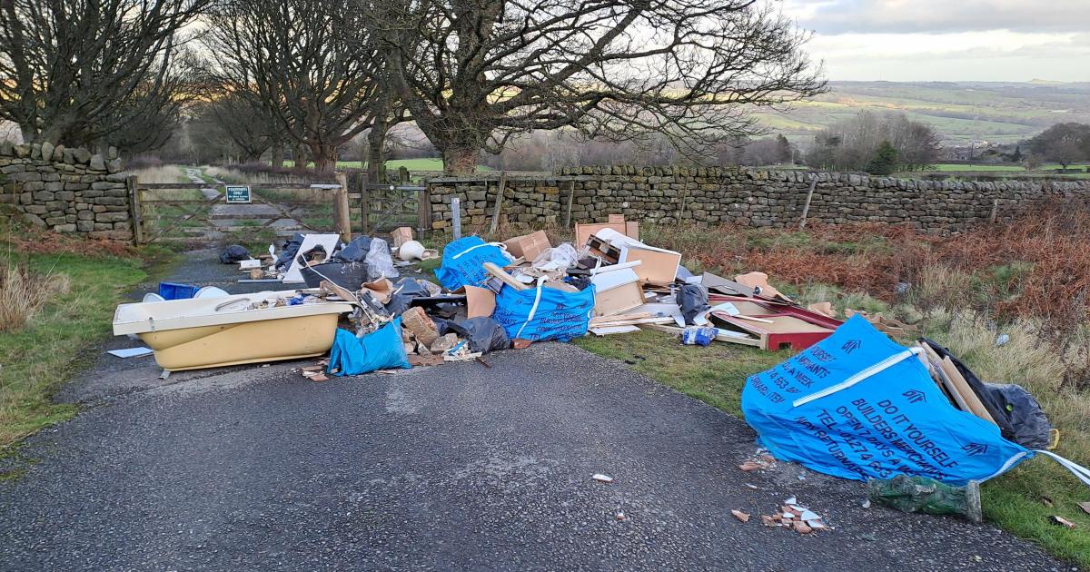 Bath and toilet amongst rubbish fly tipped on moorland road in Ilkley