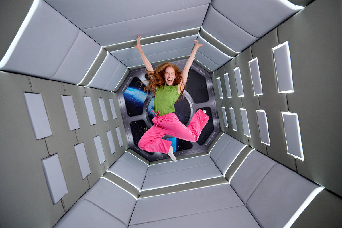 a woman jumping in a spaceship inspired room at Paradox Museum