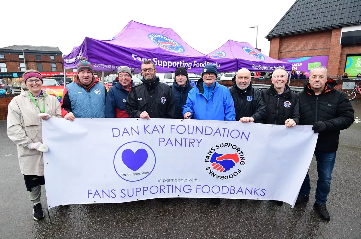 Dave Kelly  and volunteers from Fans Supporting Foodbanks with the  Dan Kay Foundation Pantry banner (Pic Andrew Teebay)