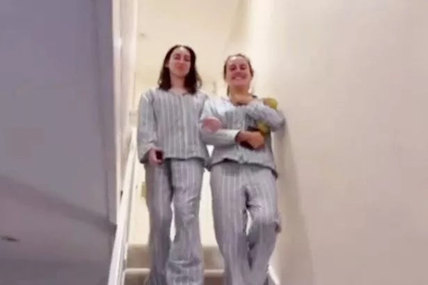 Jess and Rebecca walking down the stairs in stripey pyjamas