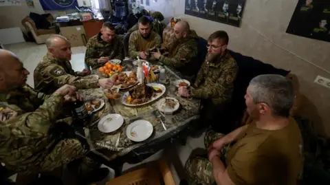 Reuters Ukrainian soldiers eating a meal around a table