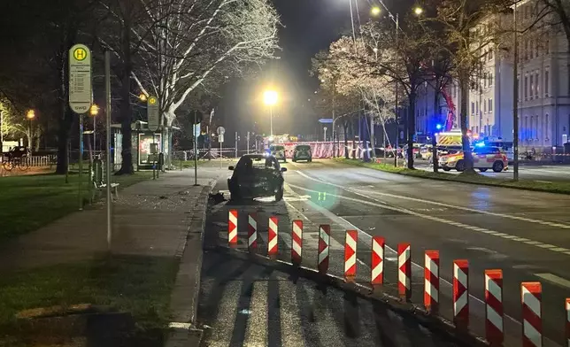 A wrecked vehicle is seen where a 32-year-old man from Azerbaijan, crashed his car into a bus stop Monday, Dec. 22, 2025, in Giessen, Germany. (AP Photo/Tom Moldoveau)