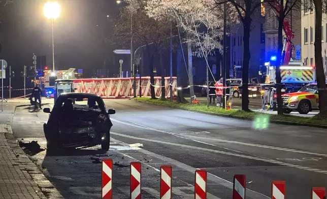 A wrecked vehicle is seen where a 32-year-old man from Azerbaijan, crashed his car into a bus stop Monday, Dec. 22, 2025, in Giessen, Germany. (AP Photo/Tom Moldoveau)