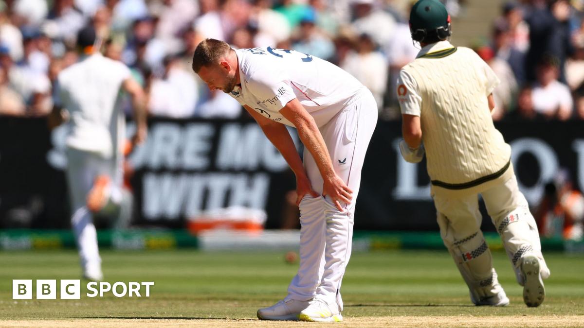 England bowler Gus Atkinson bends over to hold is legs with an apparent hamstring injury