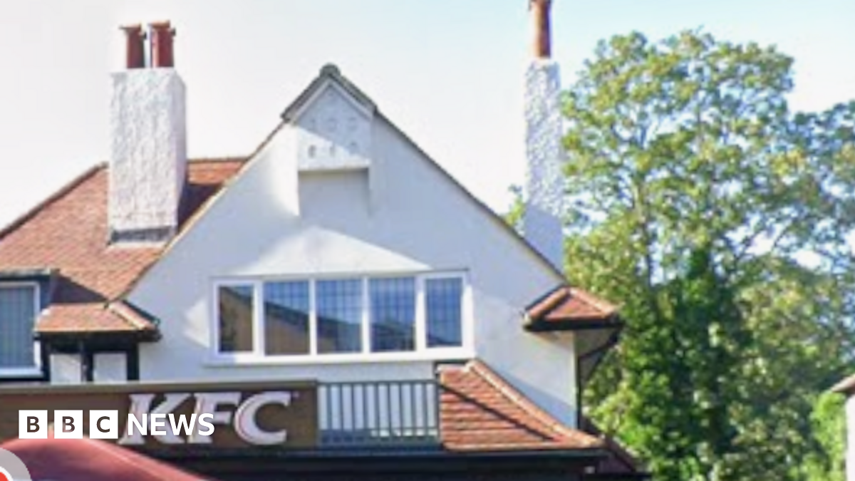 Close-up of KFC branch in West Wickham, showing the gable roof and top windows, as well as chimneys of the building