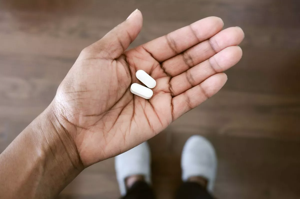 Close-up of woman holding pills in palm of hand