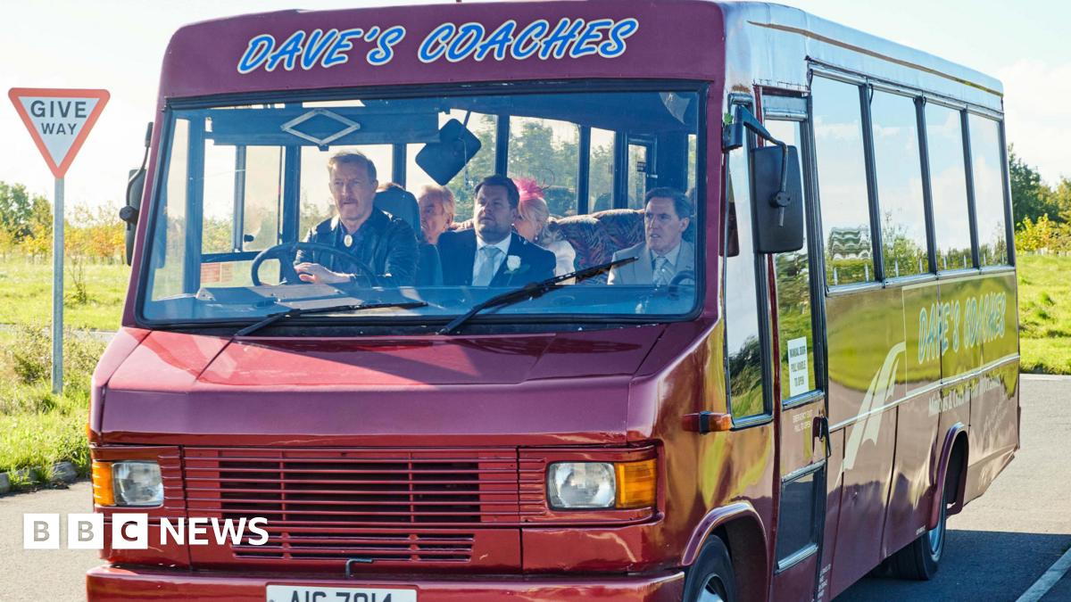 A still from Gavin and Stacey showing actor Steffan Rhodri driving the Dave's Coaches bus, with Rob Brydon, James Corden, Larry Lamb and Alison Steadman as passengers.