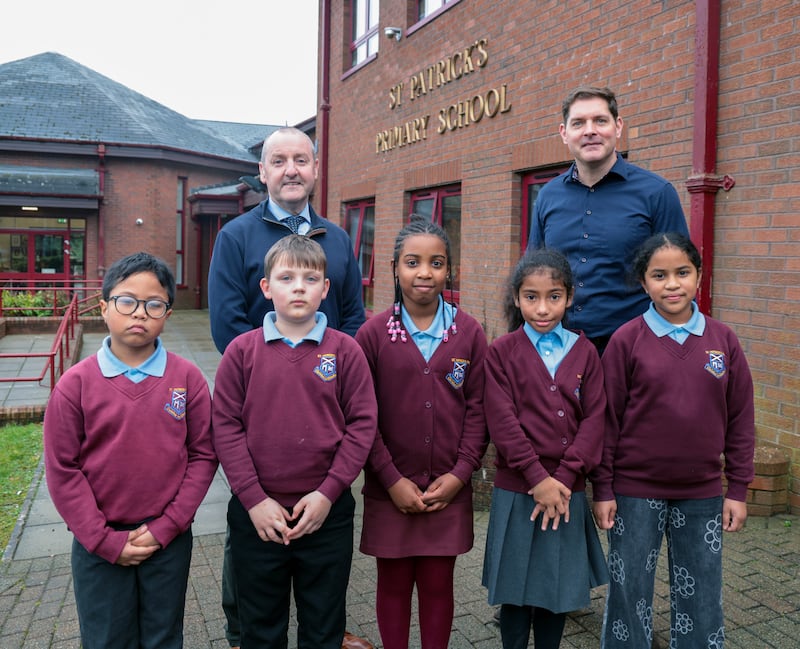 St Patrick’s Primary School principal Seamus McCreesh and singer-songwriter Malachi Cush with pupils at the Dungannon school. PICTURE: BRIAN LINCOLN