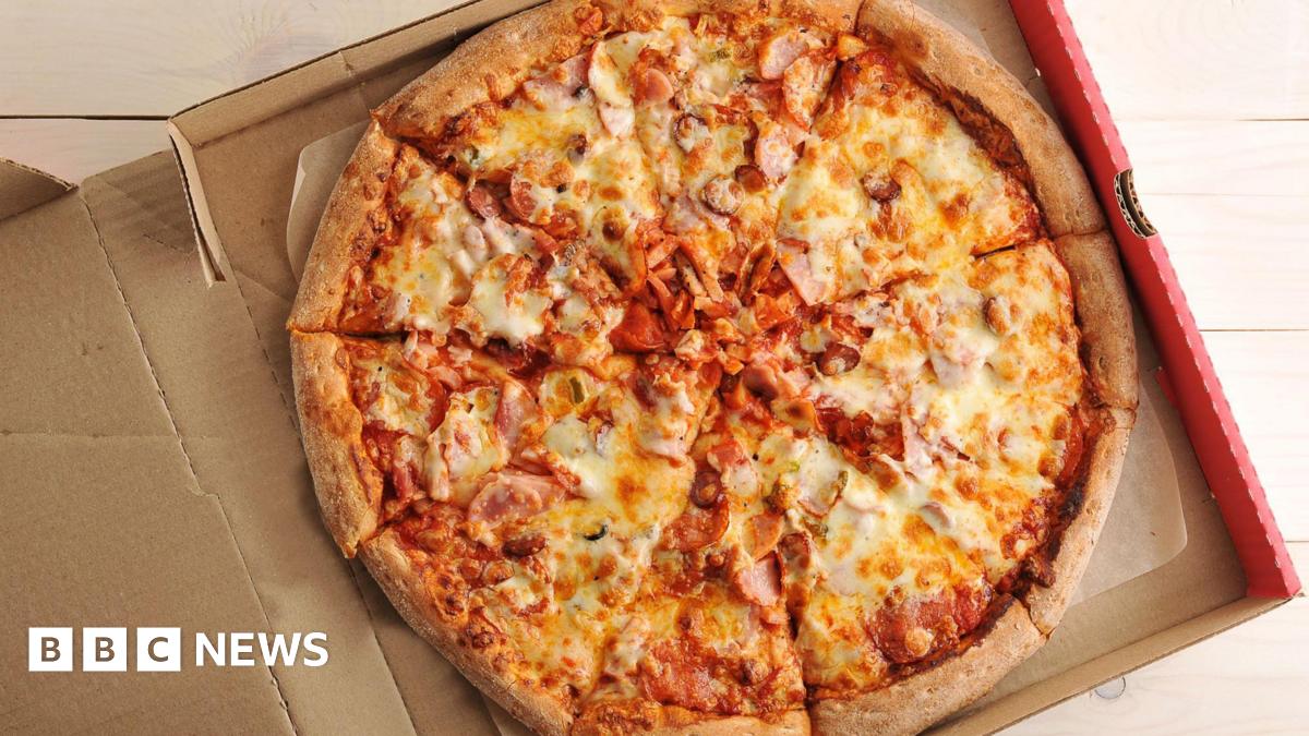 A cheese and ham pizza in a pizza box