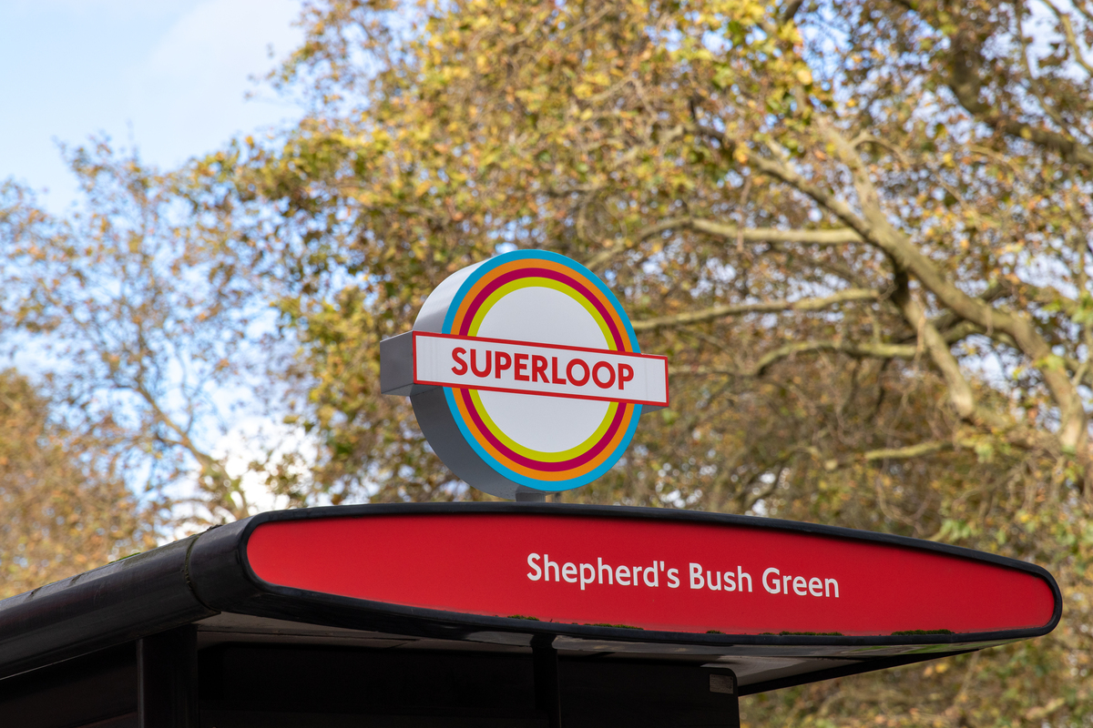 a shot of the top of shepherd's bush green bus shelter, with a superloop totem attached to the roof