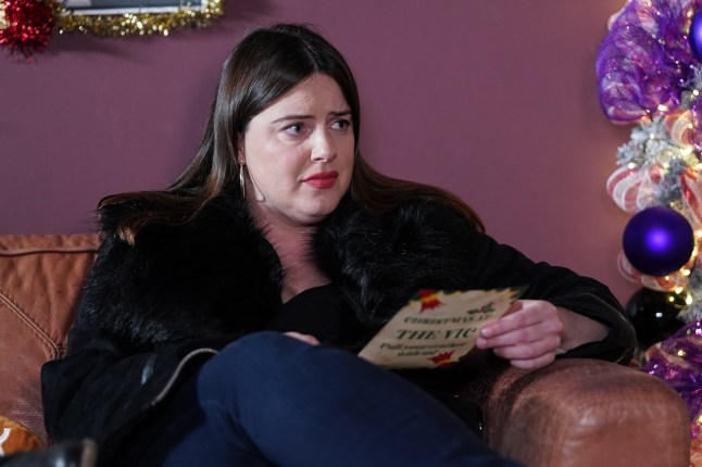Zoe Slater reading a letter on the sofa in EastEnders