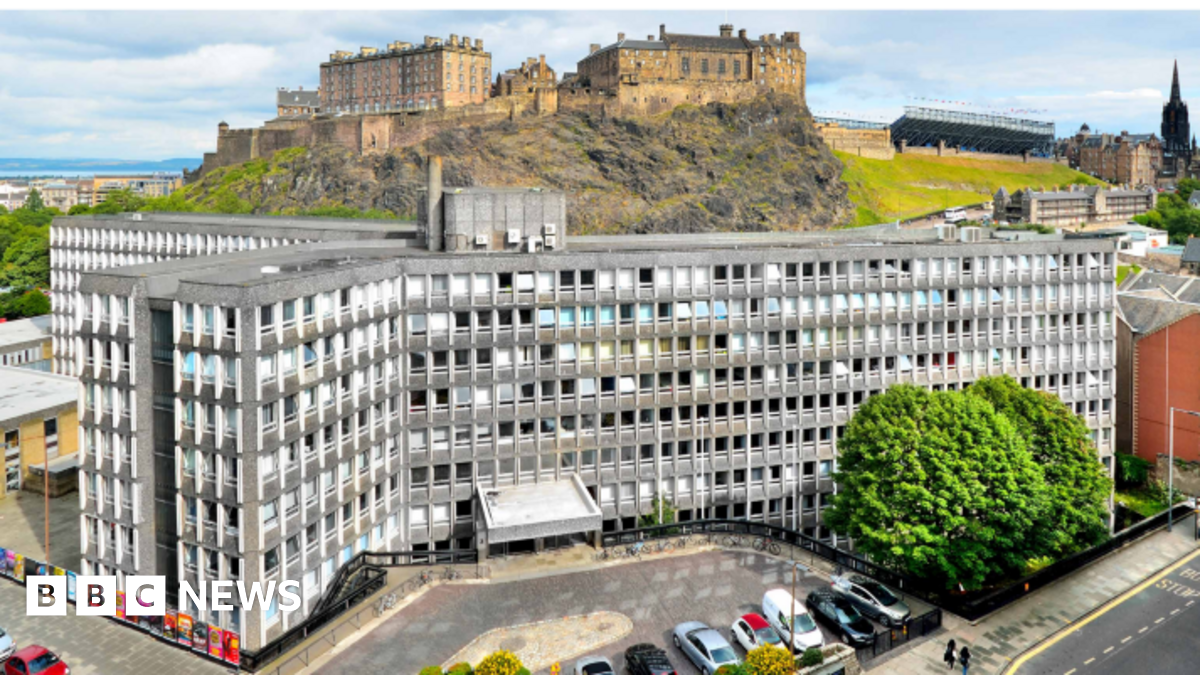 An aerial view of Argyle House, which is grey with lots of windows, designed in the brutalist style. Behind it is Edinburgh Castle.