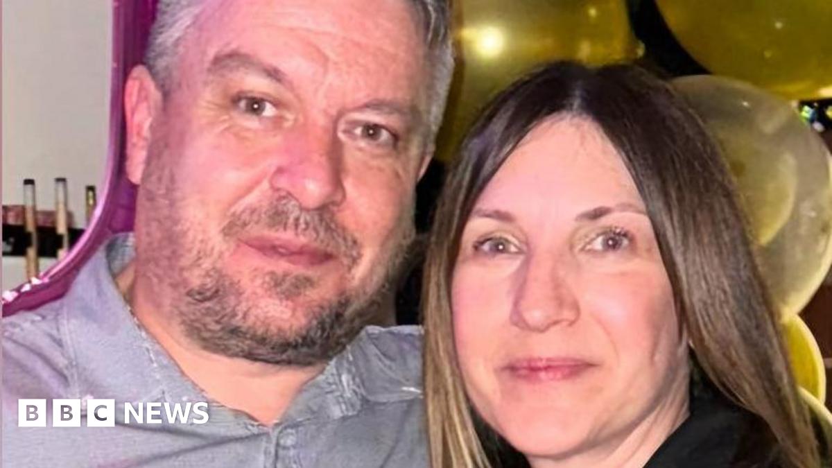 A man with dark hair and a beard in a grey shirt next to a woman with long brown hair and a dark top