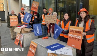 People wearing hi vis jackets and holding b anners on a picket line in Brighton
