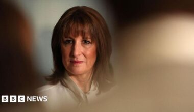 Rachel Reeves, dressed in a white blouse, can be seen in focus between the heads of an audience
