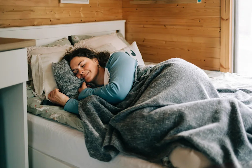 Serene woman sleeping peacefully in cozy wooden cabin bedroom