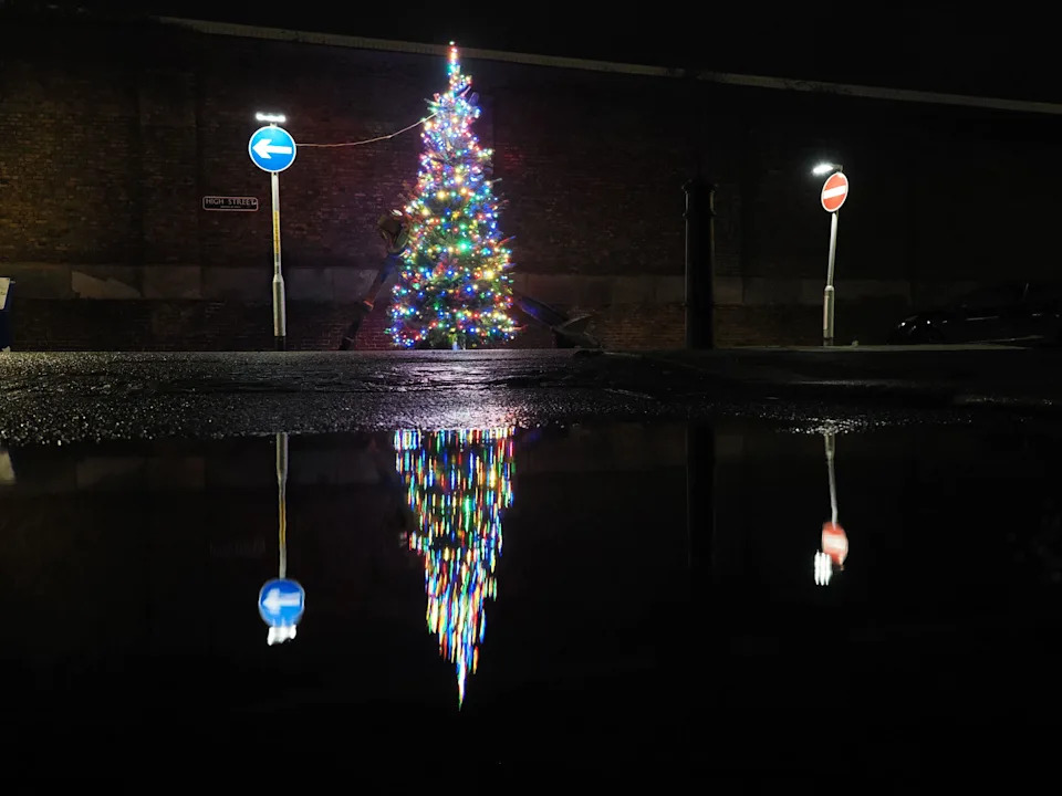 Sheerness, Kent, UK. 7th Dec, 2025. A public Christmas Tree seen reflected in a puddle in Blue Town high street in Sheerness. Credit: James Bell/Alamy Live News