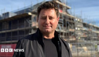 George Clarke in front of the HICSA. The building has scaffolding around it and is located just a stone's throw from the Sheepfolds leisure complex.
