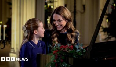 Princess Charlotte and Catherine, The Princess of Wales, sit smiling at a piano as they perform at for a Christmas Carol service